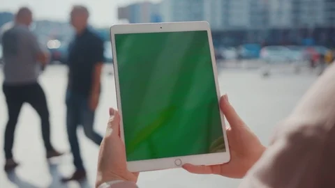 Close up hands woman using tablet device computer with green screen outdoors in Stock Footage 116460359