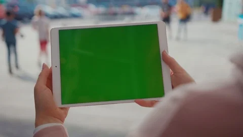 Close up hands woman using tablet device computer with green screen outdoors in Stock Footage 116461620