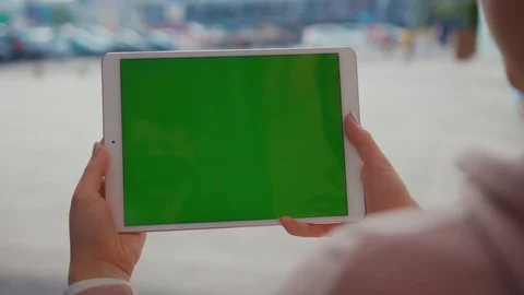 Close up hands woman using tablet device computer with green screen outdoors in Stock Footage 116461629