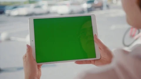 Close up hands woman using tablet device computer with green screen outdoors in Stock Footage 116462025