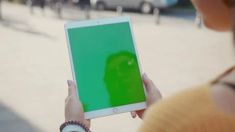 Close up hands woman using tablet device computer with green screen outdoors in Stock Footage 119426705
