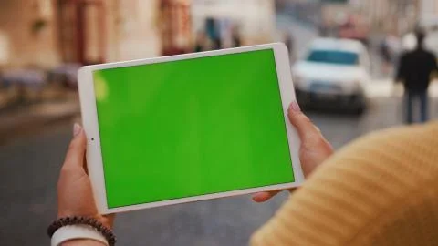 Close up hands woman using tablet device computer with green screen outdoors in Stock Photos