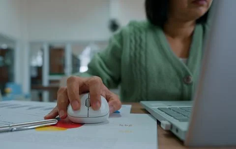 Close up hand's woman using wireless computer mouse working online on lapto.. Stock Photos