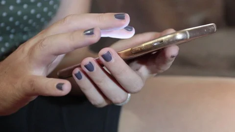 Close-up hands of a woman while typing on smartphone Video stock 116337274