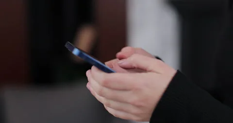 Close-up of hands of woman writes a text message on smartphone in the living Stock Footage 324809176