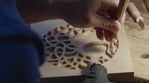 Close up hands of a wood carver using a small chisel to make a relief carving Stock Footage 240696289