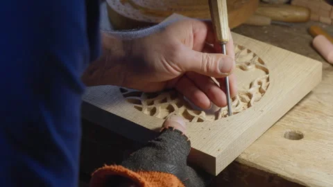 Close up hands of a wood carver using a small chisel to make a relief carving Stock Footage 240696707