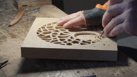 Close up hands of a wood carver using a small chisel to make a relief carving Stock Footage 240697907