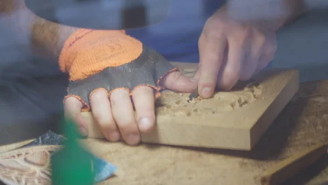 Close up hands of a wood carver using a small chisel to make a relief carving Stock Footage 240698765