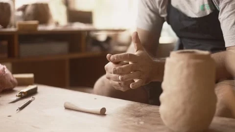 Close up hands work clay, potter kneads a piece of clay for a product Stock Footage 233725284