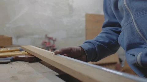 Close-up of the hands of a worker measuring a wooden board with a tape measure Stock Footage 116782641