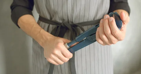 Close up of the hands of a worker or repairman in uniform holding a wrench Stock Footage 128976870