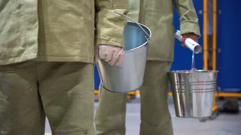 Close up hands of workers wear white gloves, hold galvanized buckets, standing  Stock Footage 126356019