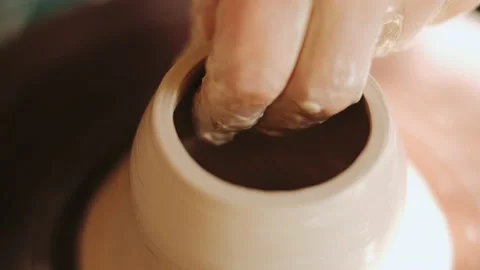 Close up of hands working clay on potter's wheel. White clay. Stock Footage 136176264