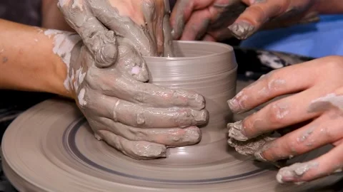Close-up of hands working with clay on a potter's wheel in a pottery studio.. Stock Footage 328831301
