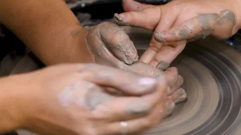 Close-up of hands working with clay on a potter's wheel in a pottery studio.. Video stock 331206402