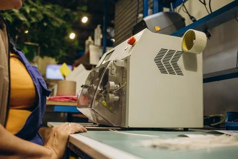 Close-up of hands working on industrial machine for cutting cable Stock Photos
