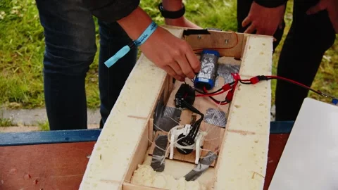 Close up of hands working on wires of self made remote controlled boat in Vídeos de archivo 277782953