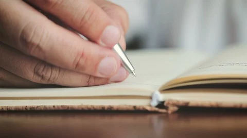 Close up hands writing on the diary book in living room Stockbeeldmateriaal 92239519