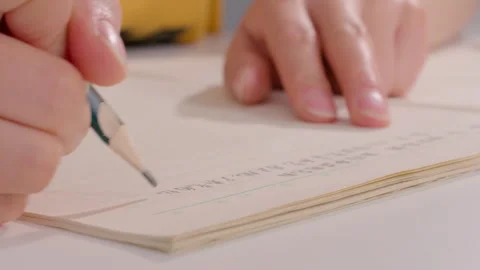Close-up of Hands Writing with Green Pencil on Lined Notebook Paper Vídeos de archivo 334845203