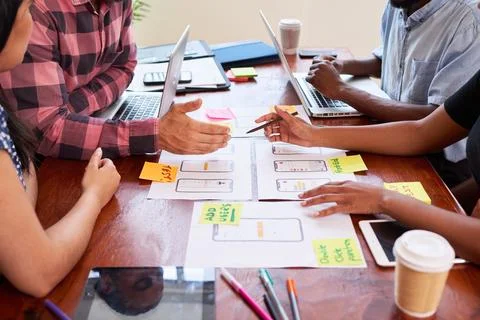 Close up of hands writing notes on mobile app layout design, coding tech Stock Photos