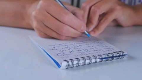 Close-up of hands writing notes in notebook with pen, taking notes on paper Stock Footage 333471211