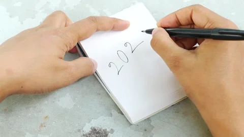 Close up of hands writing year 2023 with black pen on white notepad on text.. Stock Footage 333153258