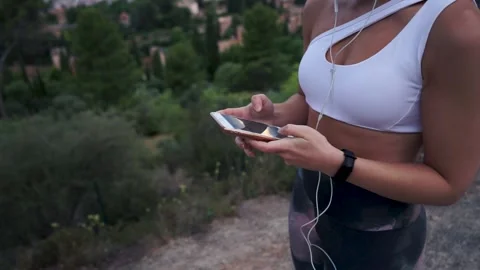 Close-up of the hands of a young athlete using her smartphone 動画素材 132872641