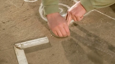 Close Up hands of a young blacksmith who draws a chalk sketch on the table using Stock Footage 77004369