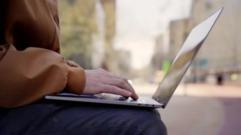 Close up of hands of young caucasian man using laptop on city streets, typing Stock Footage 153251273
