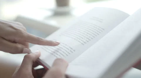 Close up hands of young couple in a cafe reading a book, outdoors. Stock Footage 67253235