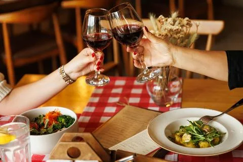 Close up of hands young couple two people clinking with glasses of red wine at Stock Photos