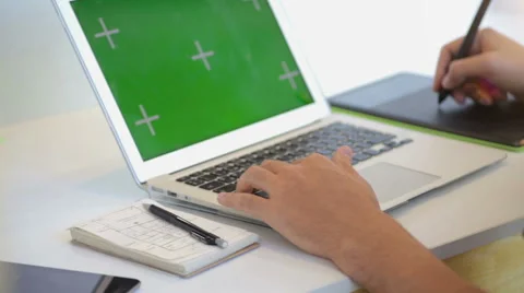Close up of hands of a young designer using a tablet and a laptop computer Stock Footage 62802796