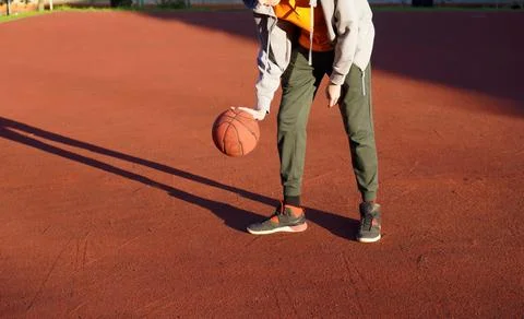 A close-up of the hands of a young man training with a basketball on a stre.. Foto stock