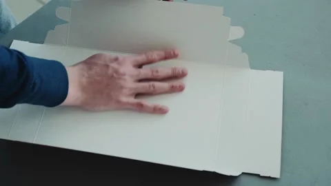 Close up hands of a young man who folds cardboard boxes for gifts Stock-Footage 169596572