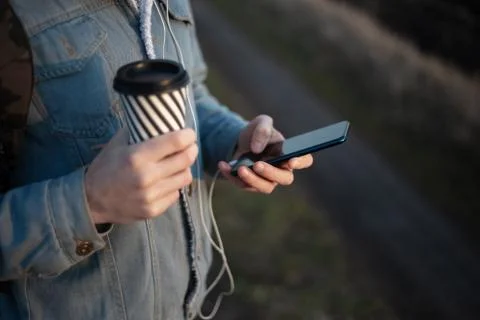 Close-up of hands of young modern guy with backpack, holding the coffee cup. Stock Photos