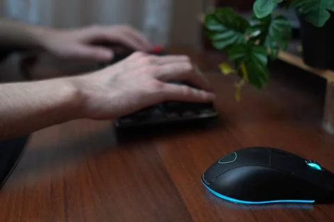 Close-up of the hands of a young programmer working on a keyboard against the 스톡 사진