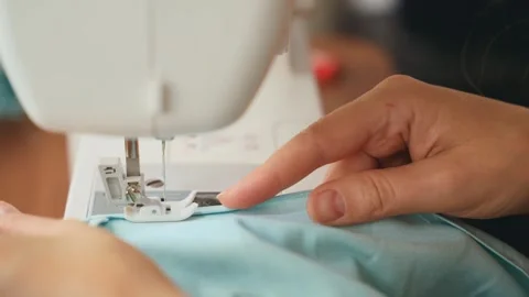 Close-up hands young woman tailor sewing clothes using sewing machine process Stock Footage 340461004