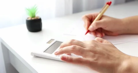 Close-up of hands young woman using calculator and paper documents for financ Stock Footage 300364042