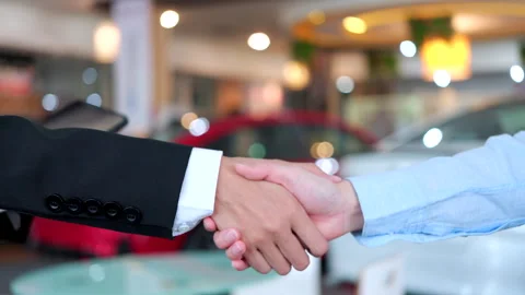 Close-up handshake between a car dealer and a buyer after signing a contract. Stock Footage 346268230