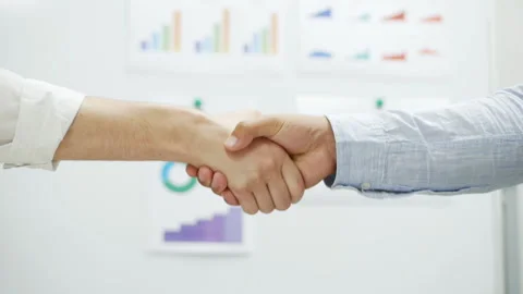 Close-up of handshake of two businessmen, graphs and charts in the background Stock Footage 141604875