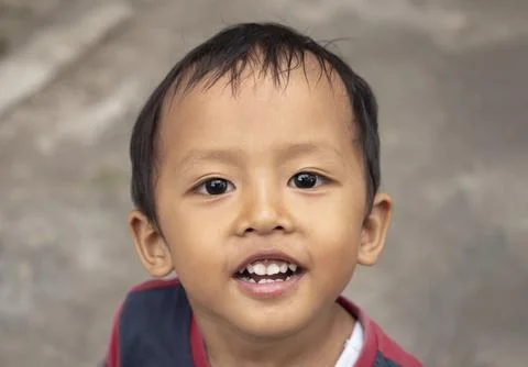 Close up of a handsome Asian boy looking at the camera, happy child face co.. Photos