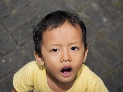 Close up of a handsome Asian boy looking at the camera, happy child face co.. 스톡 사진