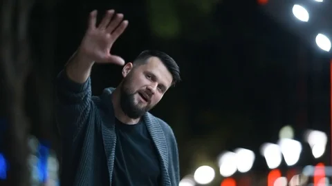 Close-up of a handsome bearded man raising his hand in farewell  and leaving 스톡 동영상 117472014
