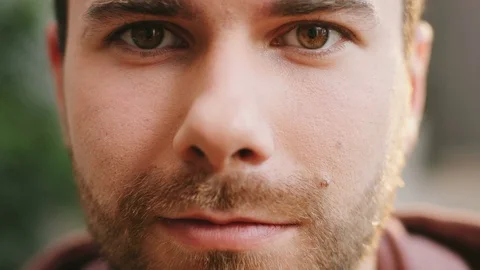 Close up of the handsome caucasian young man's face with a beard smiling to the Stock Footage 83328533