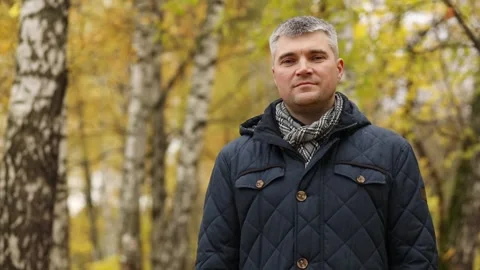 Close-up of handsome cheerful man posing on camera in autumn forest with shallow Stock Footage 276360519