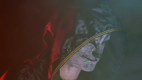 Close-up, Handsome Guy in Chen Hood with the Beast's Make-up on the Face Raises Stock Footage 88447396