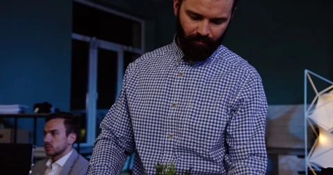 Close up of handsome man with a beard packing his stuff inside the box in the Stock Footage 82447324