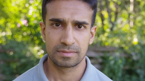 Close Up - Handsome man looks into the camera and takes a deep breath. - Slow Stock Footage 125160324