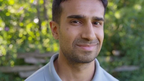 Close Up - Handsome man looks into the camera smiling - Slow Motion - shot on Stock Footage 125160424